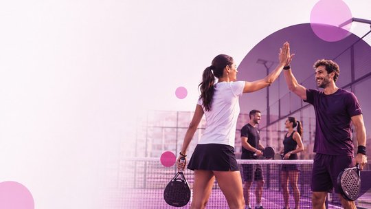 Giocatrice e giocatore di padel si battono il cinque in campo durante la EmpowHer Padel Cup